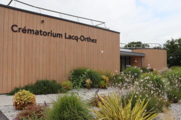 Façade du crématorium Lacq-Orthez avec un design sobre style bois et des plantations autour.